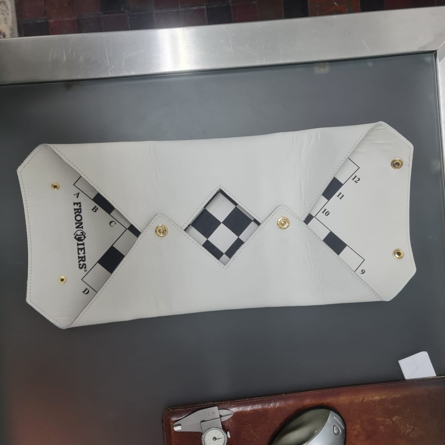 White leather FRONTIERS board partially unfolded during product development.